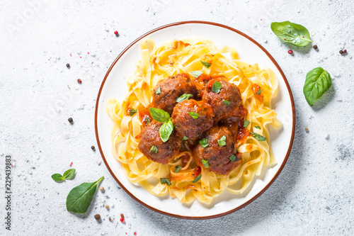 Meatballs in tomato sauce with pasta tagliatelle top view. photo