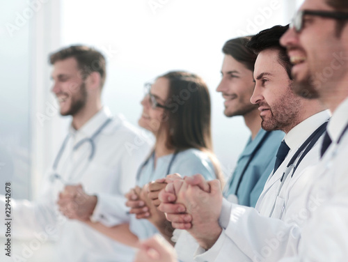 doctors sit in a row and hold hands of each other