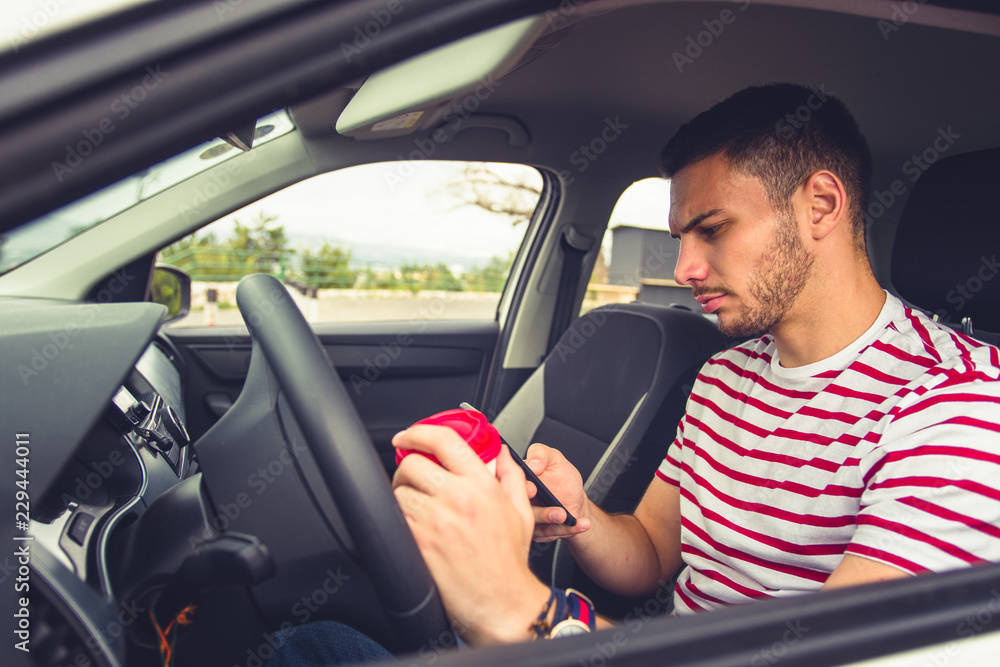 Reckless guy in a car looking at his phone Reckless guy in a car looking at his phone
