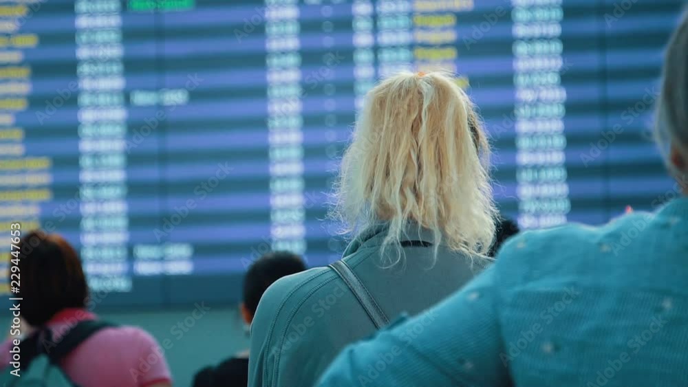 Passengers looking at timetable board screen at the airport, international flight, business man travels abroad