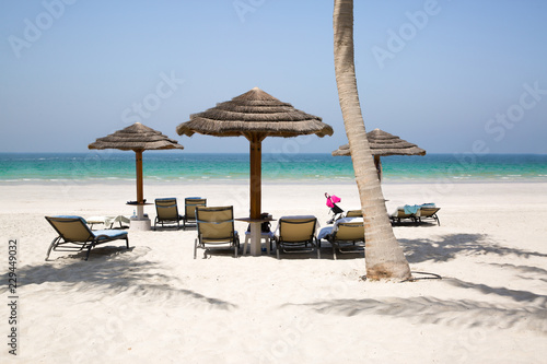 White sand beach, umbrellas, chair and turquoise water of Indean ocean, vacation and relaxing concept. © Nataliia