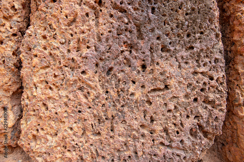 Weathered sandstone surface. Ancient rough texture of natural stone. Porous stone closeup. Rustic grungy surface photo