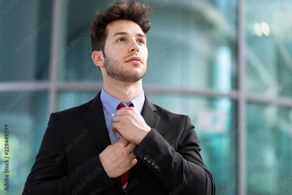 Young businessman adjusting his look outdoor Young businessman adjusting his look outdoor