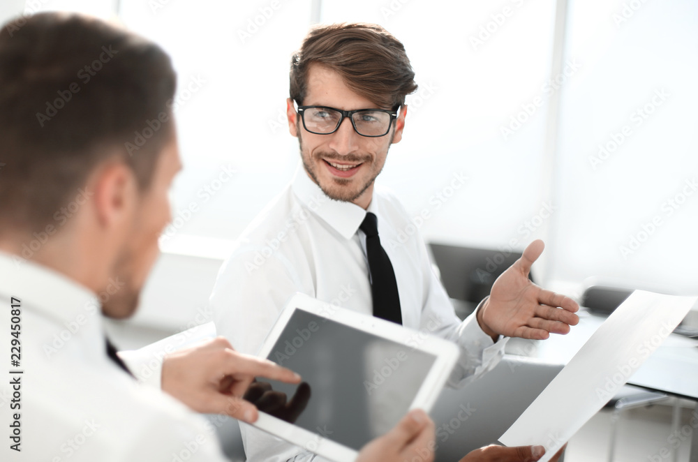 Team of two businessmen discussing new project using tablet and Team of two businessmen discussing new project using tablet and