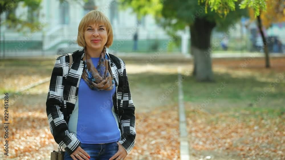 Exciting bokeh portrait of a beautiful blond woman with a bob haircut in a trendy jacket standing in a green park on a sunny day in autumn Exciting bokeh portrait of a beautiful blond woman with a bob haircut in a trendy jacket standing in a green park on a sunny day in autumn
