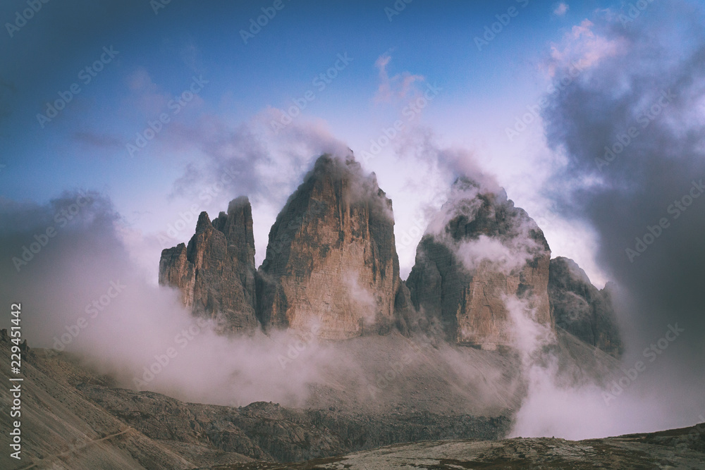 Tre Cime di Lavaredo is a symbol of the Italian Alps. The Dolomites are a UNESCO World Heritage site. Mountain peaks in the fog and clouds.
