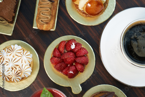 Wallpaper Mural Breakfast time with cup of hot coffee and pieces of cream cake with strawberries and raspberries, sweets dessert breakfast snacks, close-up. Berry cupcakes dessert on wooden table background, top view Torontodigital.ca