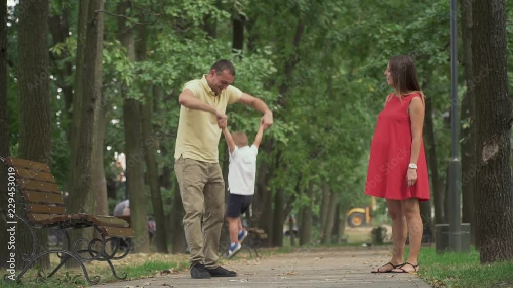Dad circles his little son in a circle n the park Dad circles his little son in a circle n the park