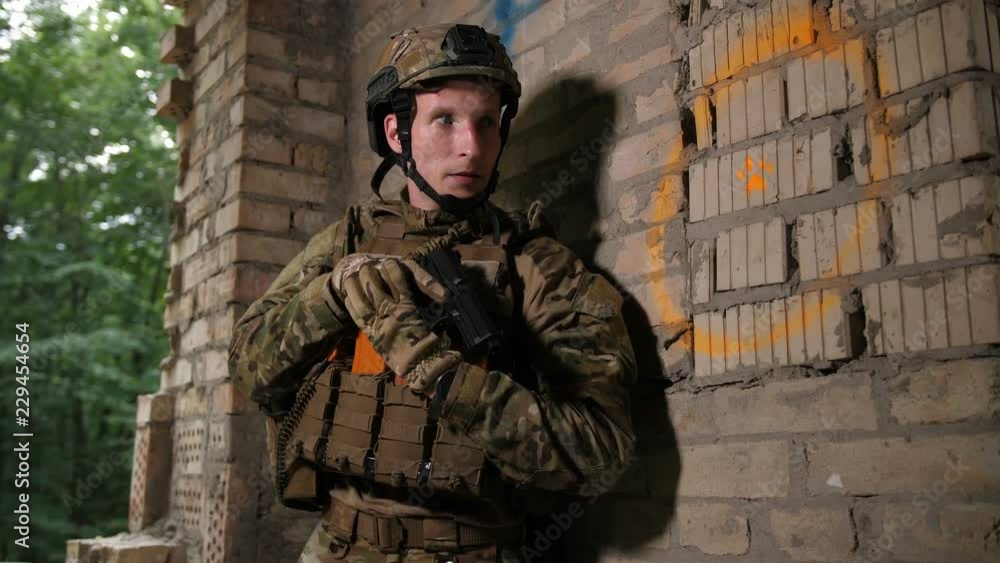 Special forces rangers in full ammunition and armed with weapons neutralizing terrorists in abandoned building. Army marines storming the premises occupied by enemy during military operation. Special forces rangers in full ammunition and armed with weapons neutralizing terrorists in abandoned building. Army marines storming the premises occupied by enemy during military operation.