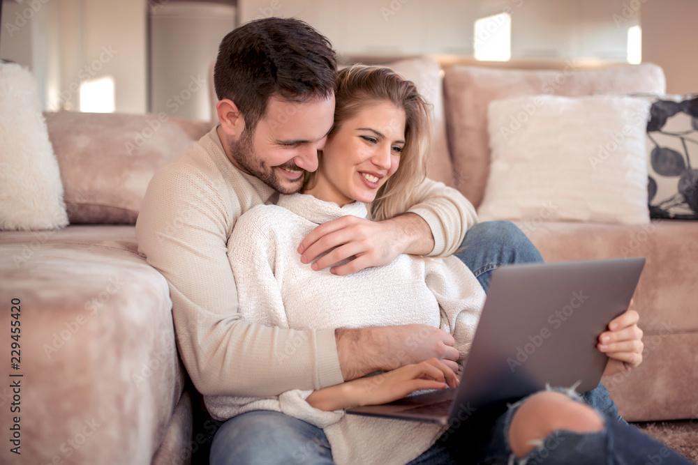Happy couple using laptop at home Happy couple using laptop at home
