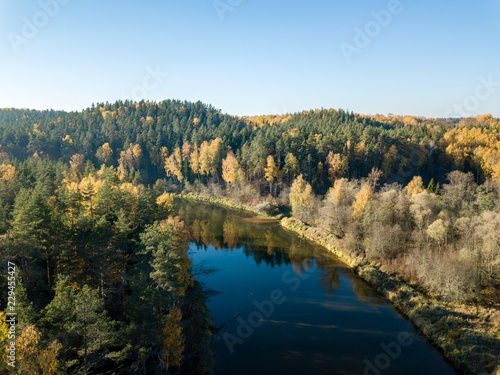 drone image. aerial view of wavy river in autumn colored forest