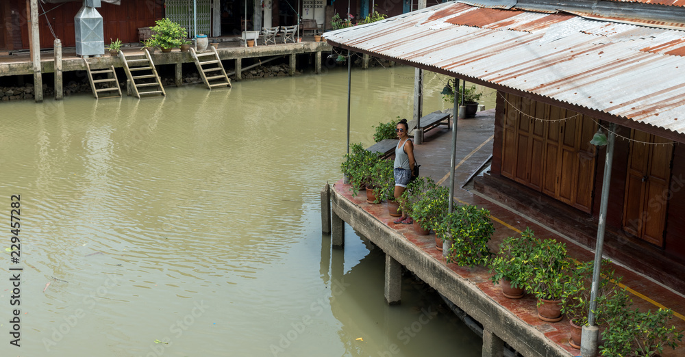 Woman standing on empty dock at floating market