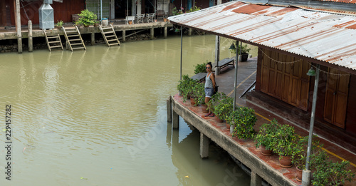 Woman standing on empty dock at floating market