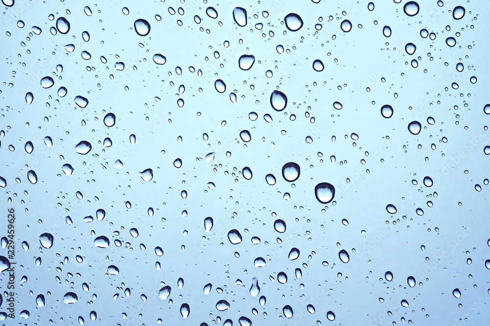 CLOSE UP IMAGE OF RAIN DROPS ON GLASS WINDOW