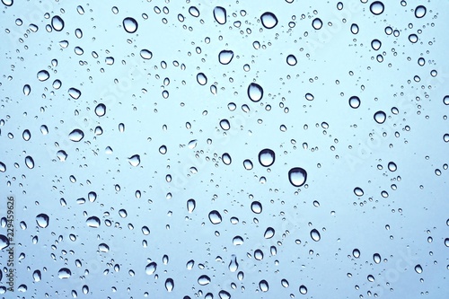 CLOSE UP IMAGE OF RAIN DROPS ON GLASS WINDOW