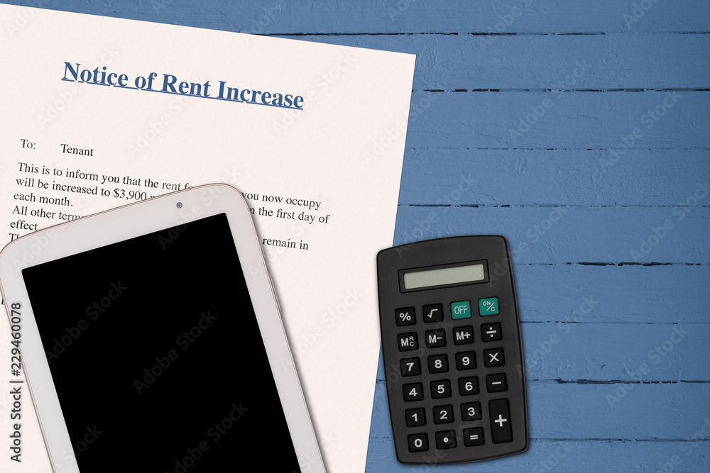 RENT INCREASE NOTICE ON BLUE OIL PAINTED TABLE WITH BLANK BLACK SCREEN TABLET, AND A CALCULATOR. (FINANCIAL DIFFICULTY) RENT INCREASE NOTICE ON BLUE OIL PAINTED TABLE WITH BLANK BLACK SCREEN TABLET, AND A CALCULATOR. (FINANCIAL DIFFICULTY)