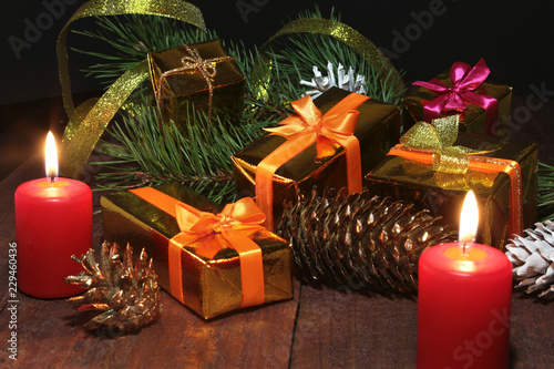 Christmas gift gold  red box with gold color bow and candles. Christmas decoration.