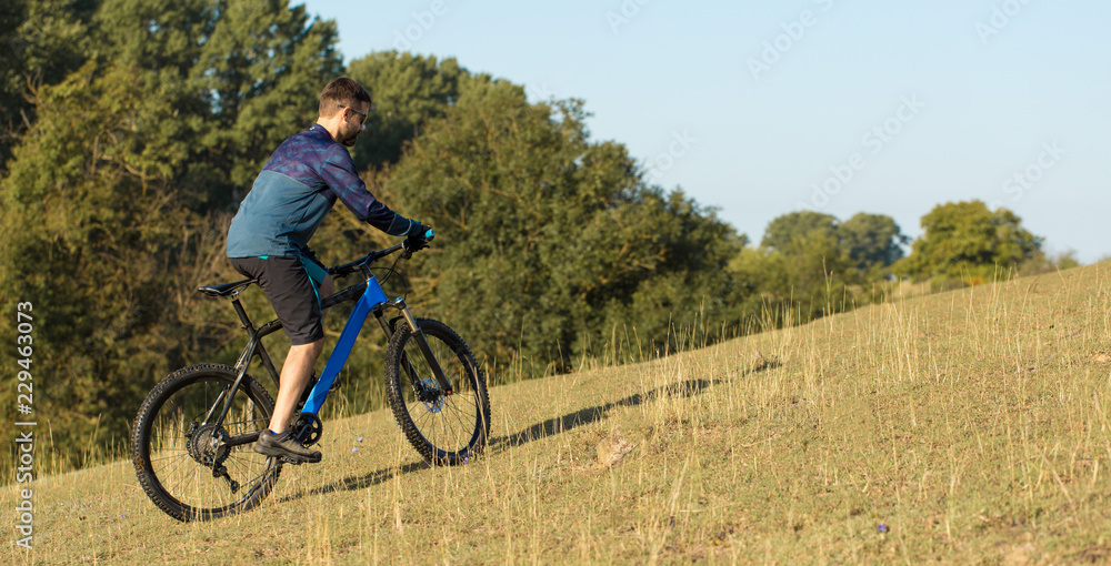 Cyclist in shorts and jersey on a modern carbon hardtail bike with an air suspension fork