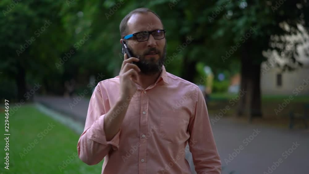 Handsome man talking on cellphone in city park Handsome man talking on cellphone in city park