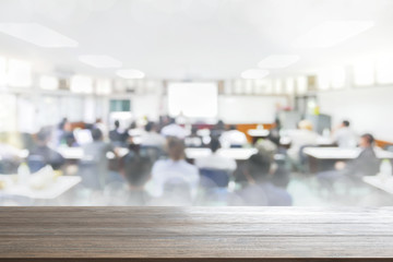 Wood Table Top Background on blurred people lecture in seminar room education or meetting concept ,abstract blur people background