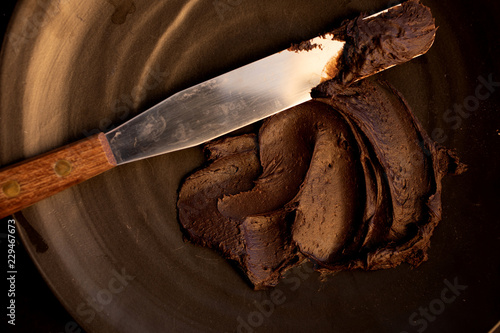 Canvas Print Delicious chocolate frosting spread on surface.