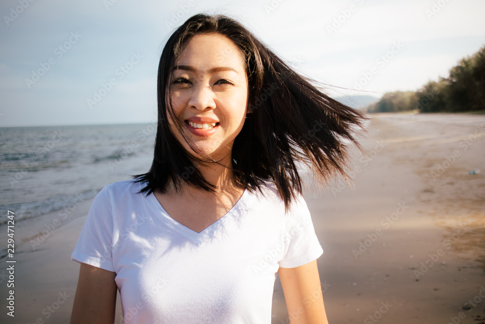 Happy and playful woman walk on the beach and play with the camera. Happy and playful woman walk on the beach and play with the camera.
