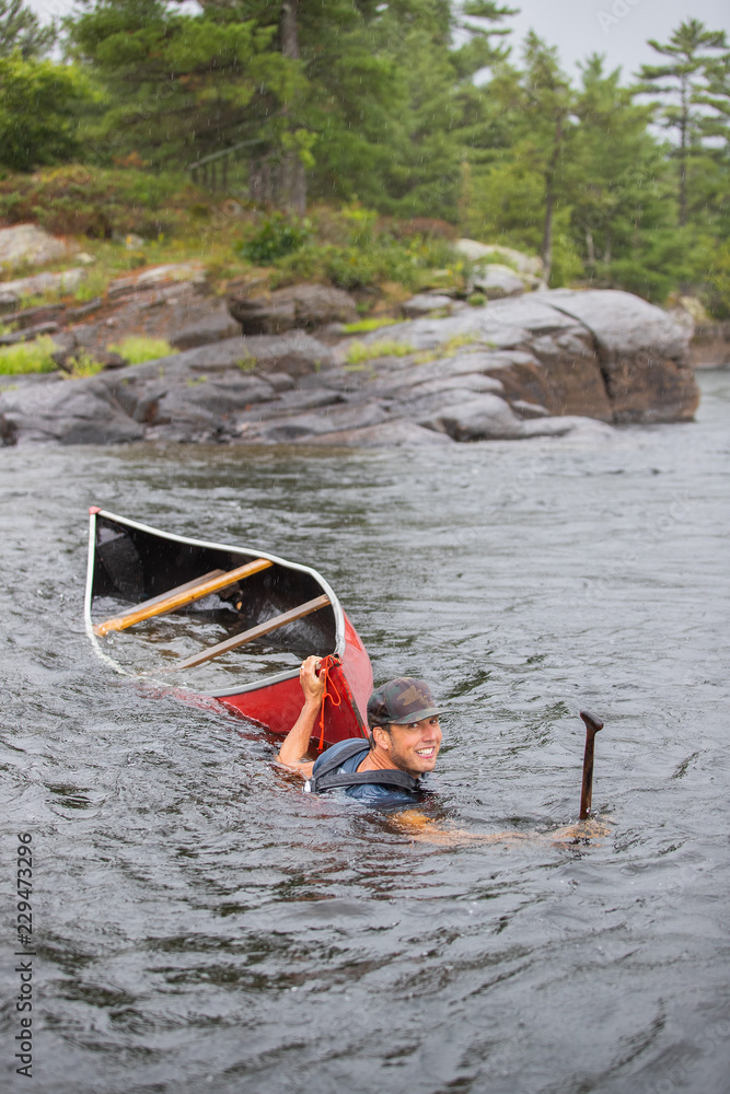 Kids playing in the rapids on a whitewater canoe trip in the Canadian wilderness