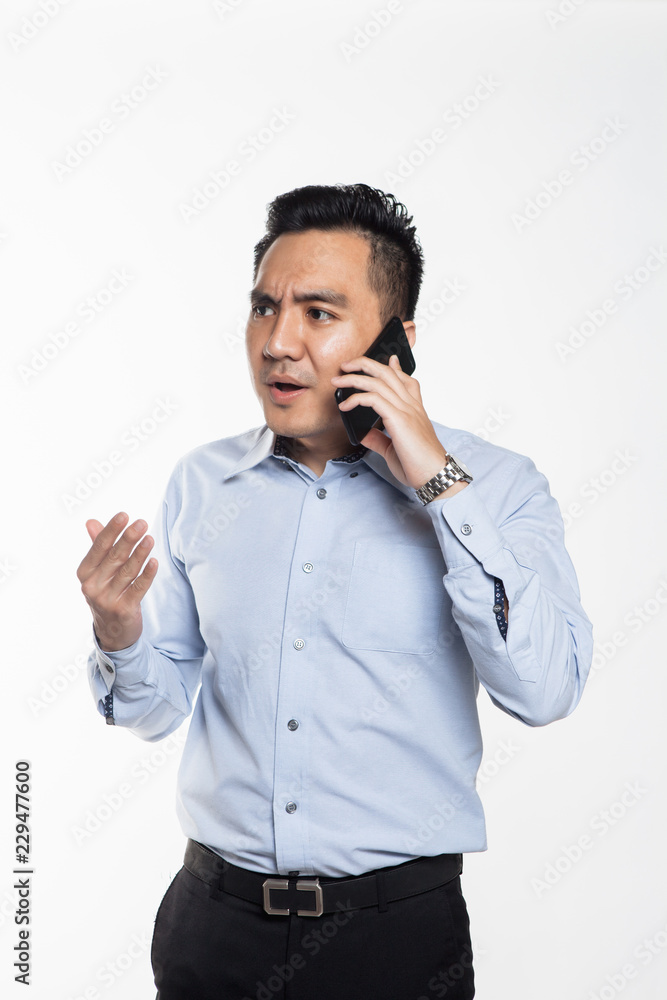 Asian man being angry while talking over the phone Asian man being angry while talking over the phone
