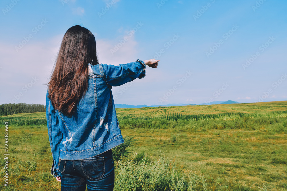 Women jean standing on green meadow with sunlight in the morning. With beautiful views of nature. Rear view Green color Plant Field Land landscape Women jean standing on green meadow with sunlight in the morning. With beautiful views of nature. Rear view Green color Plant Field Land landscape