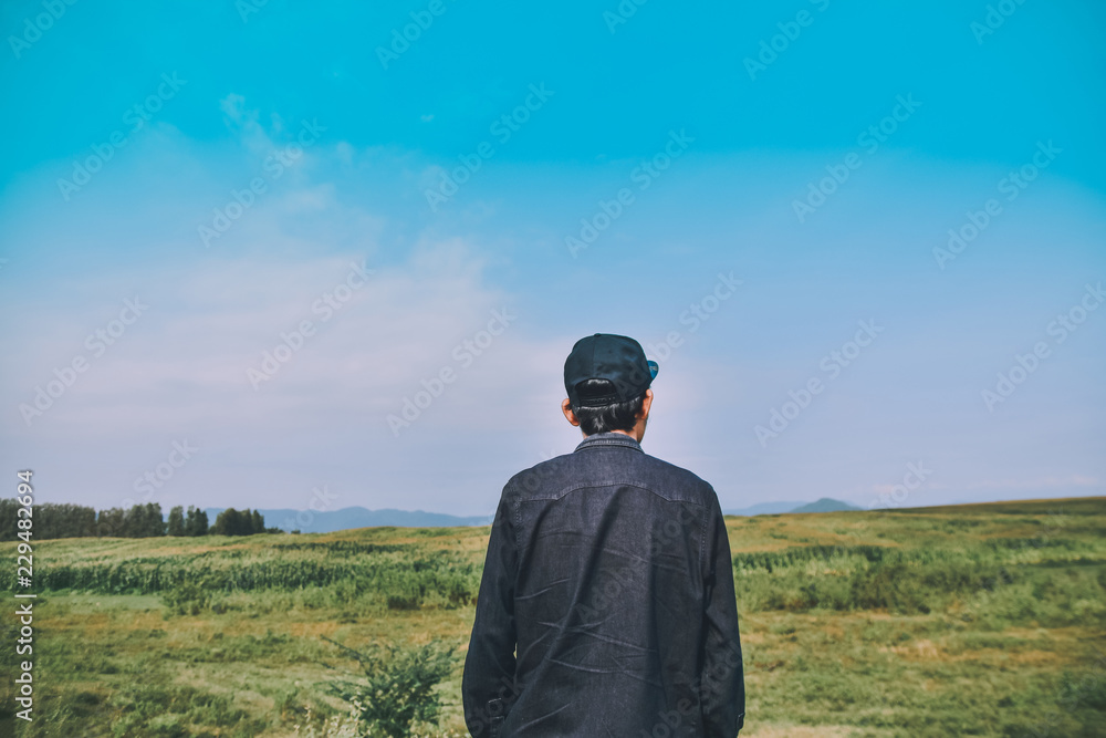 Man standing on green meadow with sunlight in the morning. With beautiful views of nature. Rear view Green color Plant Field Land landscape