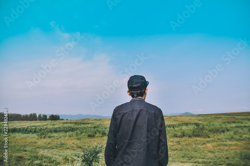 Man standing on green meadow with sunlight in the morning. With beautiful views of nature. Rear view Green color Plant Field Land landscape © Suriyo