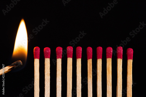 Lit match next to a row of unlit matches. The Passion of One Ignites New Ideas, Change in Others.
