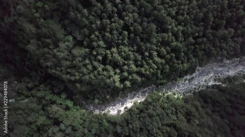 Aerial top view of the forest in Sugana Valley, Trentino, Italy with drone rotating while descends photo