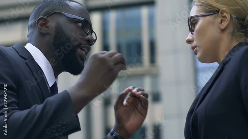 African-american boss degrading his assistant by pointing out her mistakes