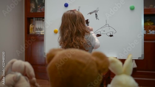 Footage from a young girl drawing in a board. photo