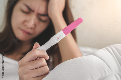 wellness and healthy concept, infertility problem,Unhappy young asian woman holding pregnancy test showing a negative result, Selective focus.