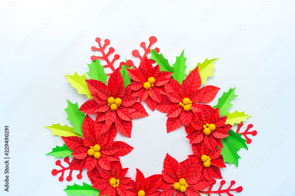 Obraz premium Paper flower poinsettia and leaves of holly