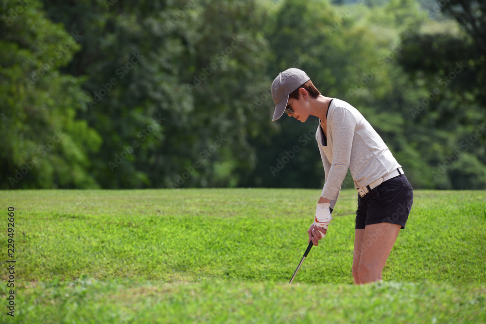 Asian woman playing golf on a beautiful natural golf course Asian woman playing golf on a beautiful natural golf course
