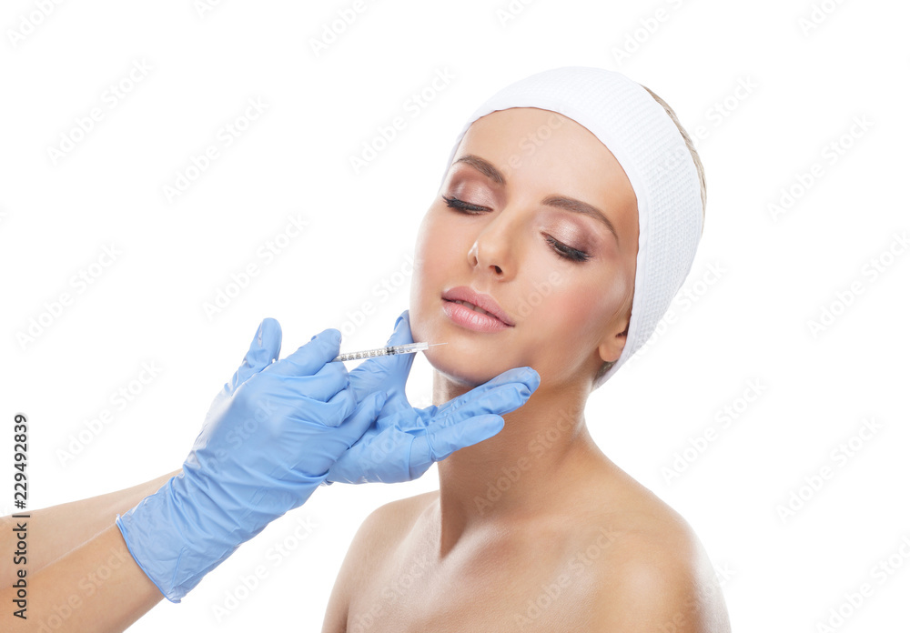 Doctor injecting in a beautiful face of a young woman. Plastic surgery concept. Doctor injecting in a beautiful face of a young woman. Plastic surgery concept.
