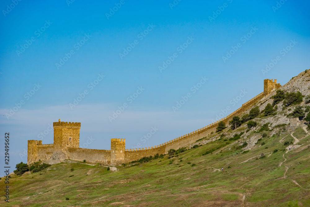 Genoese fortress on top of the mountain against the blue sky.