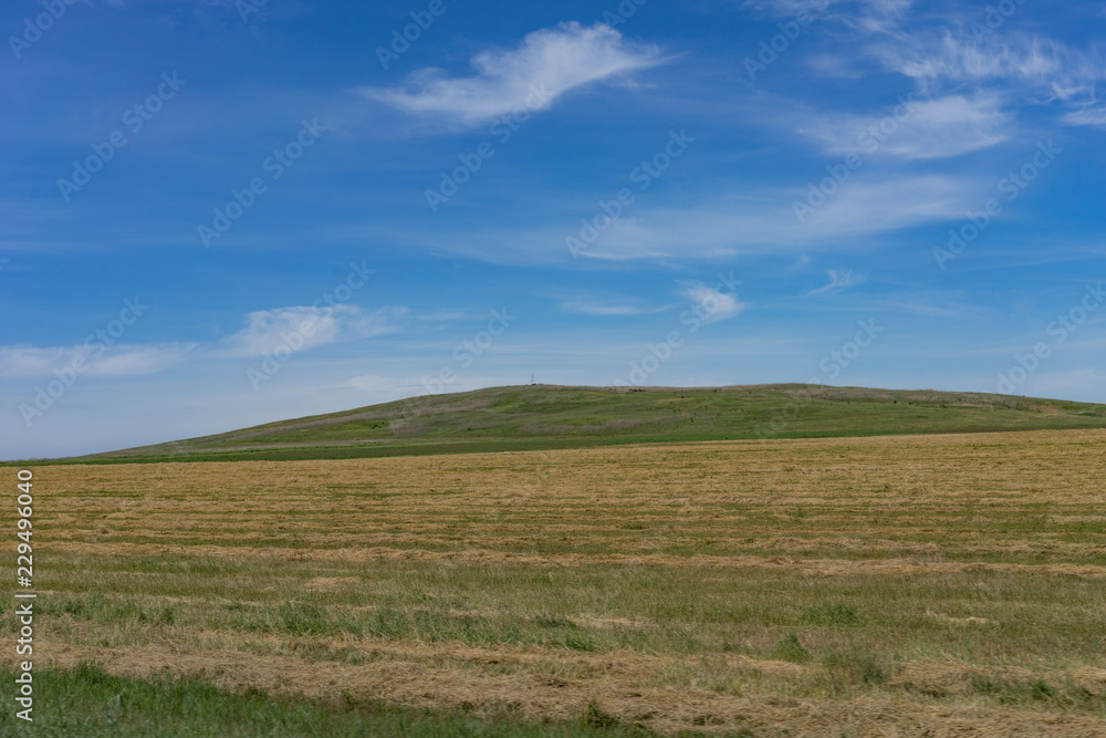 Natural landscape with hills on blue sky background.