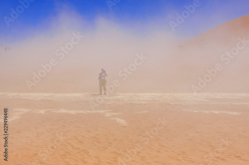 Namib Naukluft national Park / Local sandstorm on the dead lake plateau. In the depths of the sandstorm is a tourists