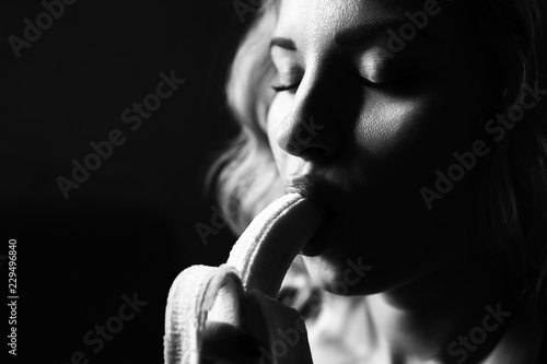 Portrait of a girl with a banana on a black background photo