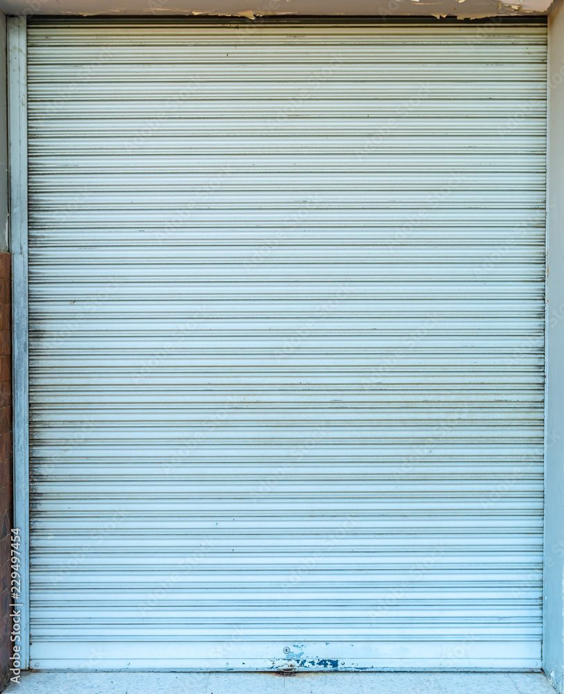 Old grunge weathered and dirty sky blue metal roller shutter door. Old grunge weathered and dirty sky blue metal roller shutter door.
