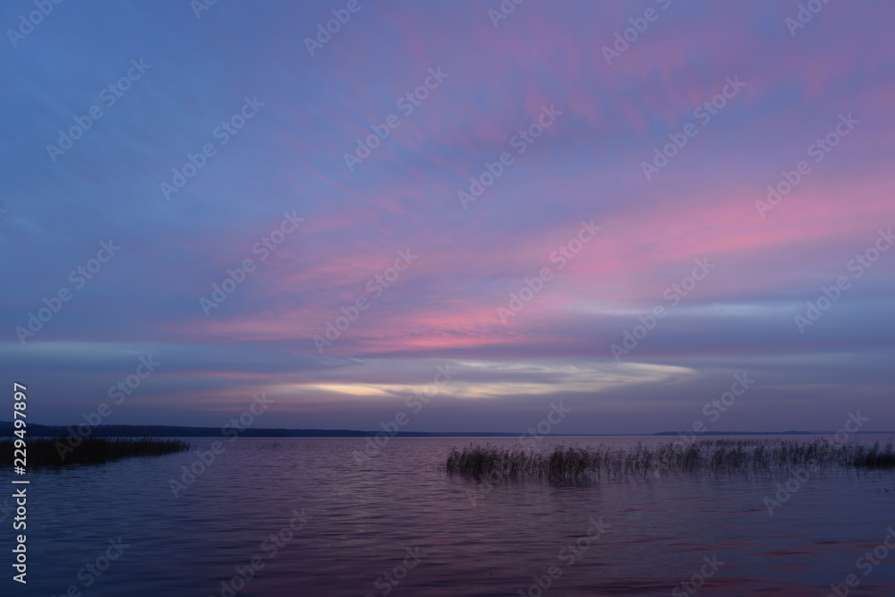 Fototapeta premium Blue sky in twilight glow above the water of the lake on a warm autumn evening