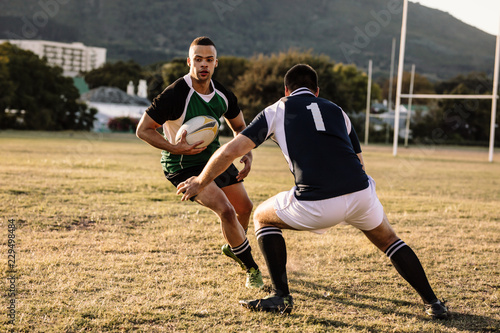 Rugby players tackling during game