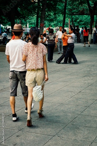 young people waling in a park while people dancing in the background