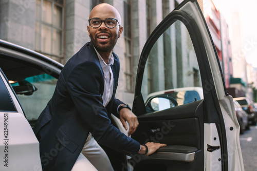 Cuadro en lienzo Young businessman getting down from car
