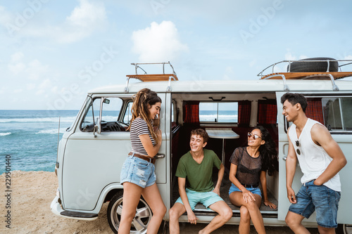 happy hipster enjoy holiday while leaning at their vintage van