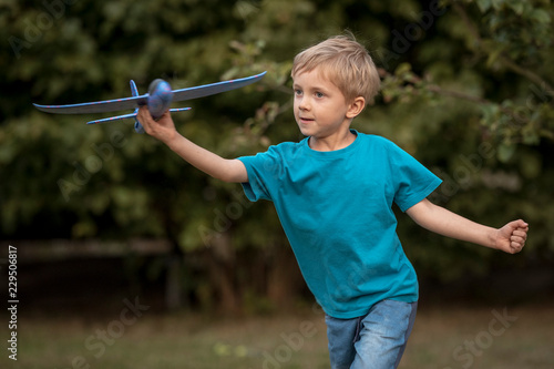 Boy playing in the garden with toy airplane